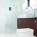 Đá cẩm thạch trắng tự nhiên kết hợp với cửa kính tạo nên không gian tươi sáng,  thoáng mát cho nhà tắm